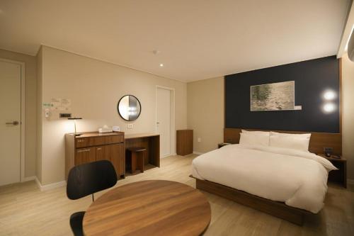 a bedroom with a bed and a desk and a table at Anook Hotel Suwon Ingye in Suwon