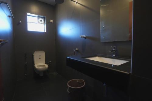 a bathroom with a sink and a toilet and a window at Hotel ASG Grand in Ranipet