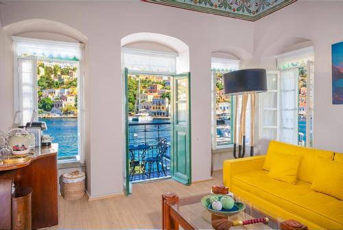 a living room with a yellow couch and windows at "LOS" 1 Neoclassic Harbour View in Symi