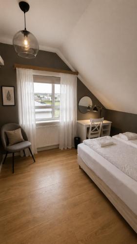 a bedroom with a bed and a desk and a window at Grindavik Guesthouse self check in & out in Grindavík