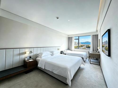 a hotel room with two beds and a large window at 威海卫大厦 Weihaiwei Hotel in Weihai