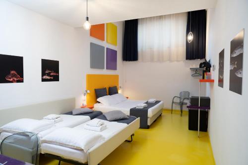 a room with four beds in a room with colorful walls at Correra 241 Lifestyle Hotel in Naples