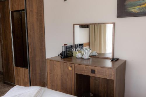 a mirror on top of a wooden dresser in a room at SOI Hotel & Casino in Svilengrad