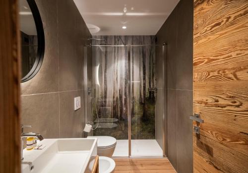a bathroom with a shower and a toilet and a sink at Residence Lastei in San Martino di Castrozza