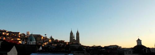 a view of a city skyline with a cathedral at Casa Hotel Las Plazas in Quito