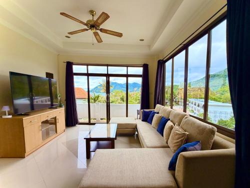 a living room with a couch and a flat screen tv at Viking House Villa Deluxe in Ko Tao