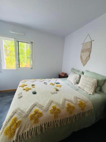 a bedroom with a bed with a yellow and white comforter at Forest Garden Retreat with Pool near the Beach in Seignosse