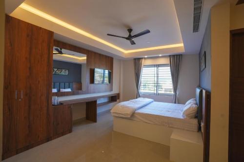 a bedroom with a bed and a desk and a ceiling at Hotel ASG Grand in Ranipet