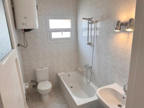 a bathroom with a toilet and a tub and a sink at Beachfront Villa Sea View First Row in Dawwār ‘Abd Allāh