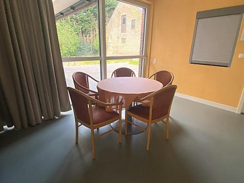 a dining room with a table and chairs and a window at Sophia-Elvira in Diksmuide