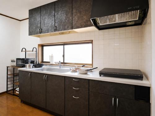 a kitchen with a sink and a window at Kokonimo Yotsukaido in Yotsukaidō