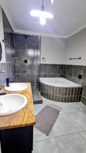 a bathroom with two sinks and a tub at Kaleaba House on the Riverside in Parys