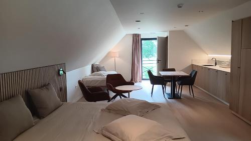 a hotel room with a bed and a table with chairs at Huis Leon in Houthulst