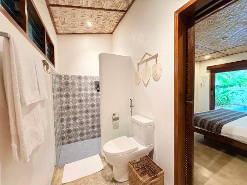 a bathroom with a toilet and a shower at Yumi Villas in San Vicente