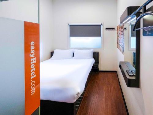 a bedroom with a white bed and a window at easyHotel Amsterdam City Centre South in Amsterdam