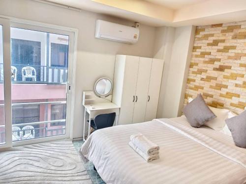 a bedroom with a bed and a desk and a window at 3-bedroom apartment, Patong, Palm Spring 602 in Patong Beach