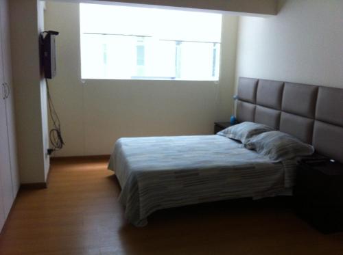 a bedroom with a bed with a large window at Departamento Miraflores in Lima