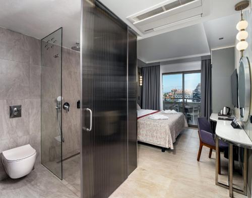 a bathroom with a shower and a bedroom at Side Alegria Hotel & Spa - All Inclusive-Adult Only in Side