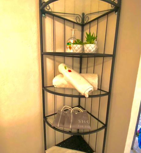 a black rack with towels and a bag in a bathroom at George's place in Plytra