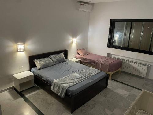 a bedroom with two beds and a window at DarNejib, El Wafa City, Hammamet-Nabeul in Nabeul