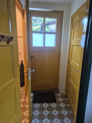 a hallway with a door and a tile floor at Morgenstond in Groesbeek