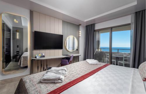 a hotel room with a bed and a television at Side Alegria Hotel & Spa - All Inclusive-Adult Only in Side