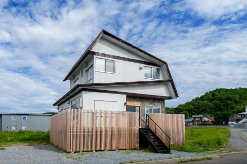a house with a fence in front of it at Rusutsu Backcountry Lodge in Kimobetsu