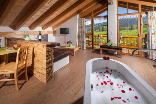 a living room with a bath tub and a table at Ferienwohnung Roislerlehen in Bischofswiesen