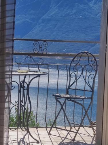 a table and chairs on a balcony with a view of the ocean at Casa Cristina - Vista Lago in Tignale