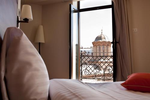 a bedroom with a bed and a view of a building at Europa Royale Bucharest in Bucharest