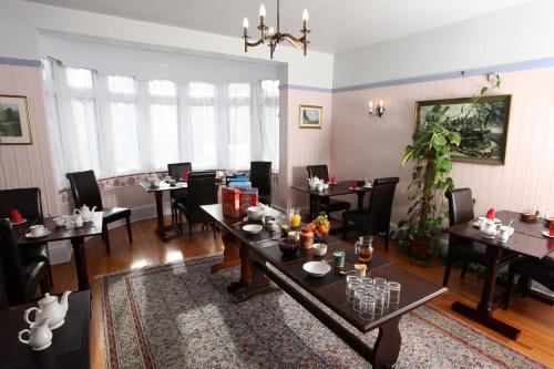 a dining room with tables and chairs and a dining room at Cranston House in East Grinstead