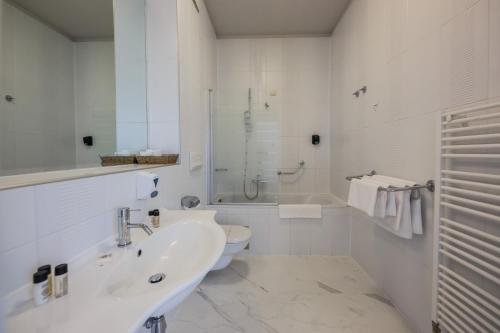a white bathroom with a sink and a toilet at Art Hotel in Split