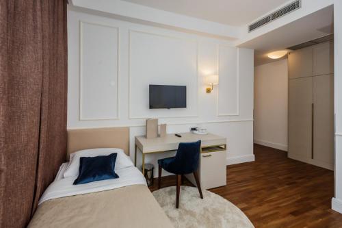 a bedroom with a bed and a desk and a tv at Art Hotel in Split