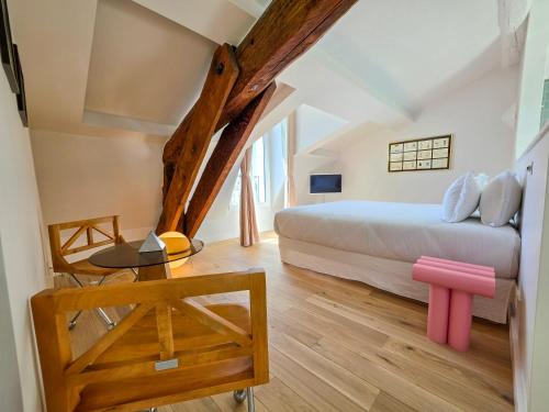 a bedroom with a bed and a wooden floor at Hôtel L'orque Bleue in Sète