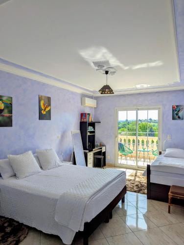a bedroom with a bed and a desk and a window at Jardhelena in Jardin