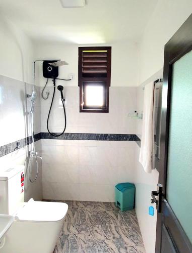 a bathroom with a toilet and a sink and a window at Mahagedara Hiriketiya in Dickwella