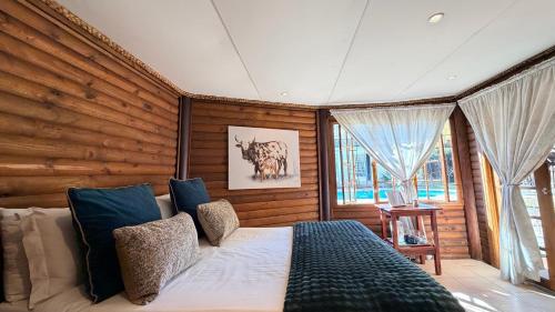 a bedroom with a bed and a large window at Midrand Manor Guesthouse in Midrand