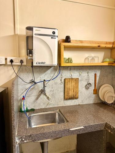 a kitchen with a sink and a microwave at Harmals Studios & Apartments in Arambol