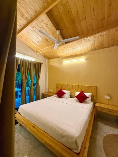 a bedroom with a large bed with red pillows at Harmals Studios & Apartments in Arambol