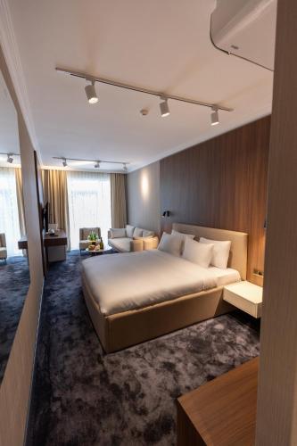 a bedroom with a large bed and a living room at SOI Hotel & Casino in Svilengrad