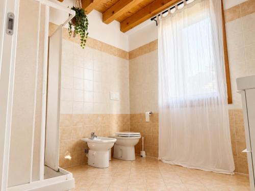 a bathroom with a toilet and a sink and a window at Appartamento Donà 2 in Rovigo