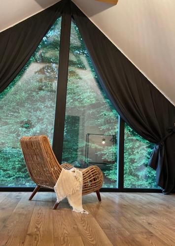 a room with a chair and a large window at Joli Chalet in Râşnov