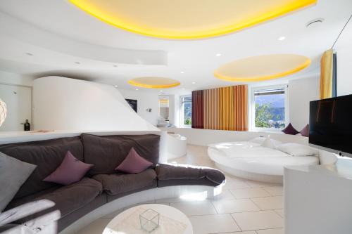a living room with a couch and a tv at Bio Wellnesshotel Pazeider in Marlengo