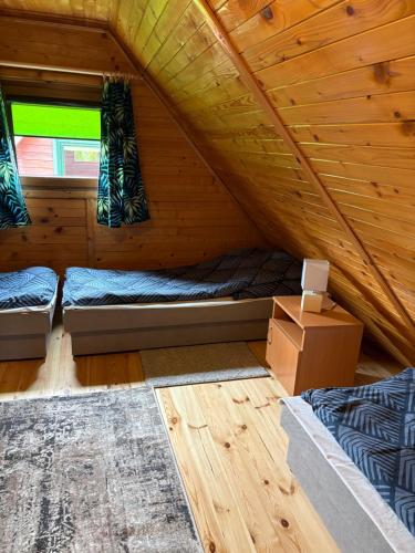 a room with two beds in a wooden cabin at Domki Lazur in Jastrzębia Góra