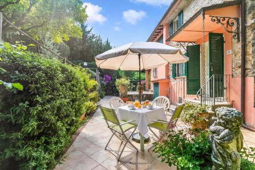 a patio with a table and an umbrella at Villa Aurora with Sea View in Seravezza