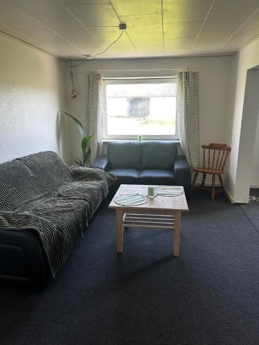 a living room with a couch and a coffee table at Small house in rural surroundings in Gelstrup