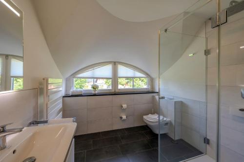 a bathroom with a toilet and a sink and a shower at Haus Tadder in Born