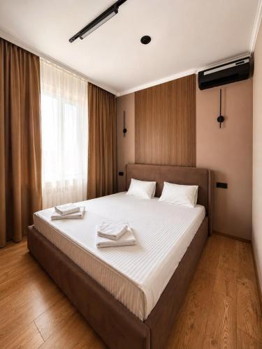 a bedroom with a large bed with two towels on it at Гостиница Балхаш in Balqash