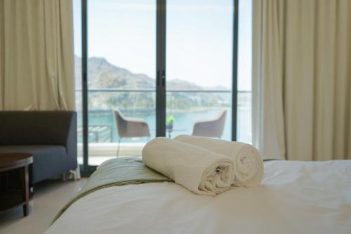 a hotel room with a bed with towels on it at Al Dana H2O Beachfront Villa with a private pool, Al Dana Island Sharm Fujairah in Sharm