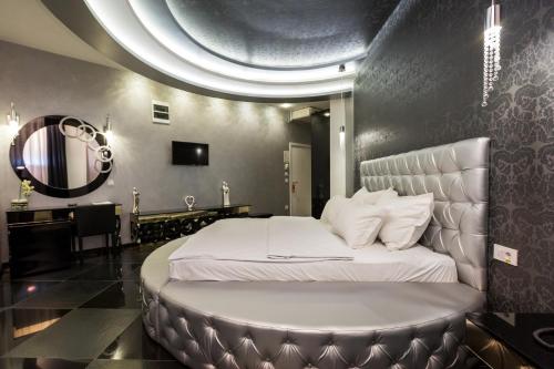 a bedroom with a large bed with a round bedvisor at Hotel Crystal Light in Niš